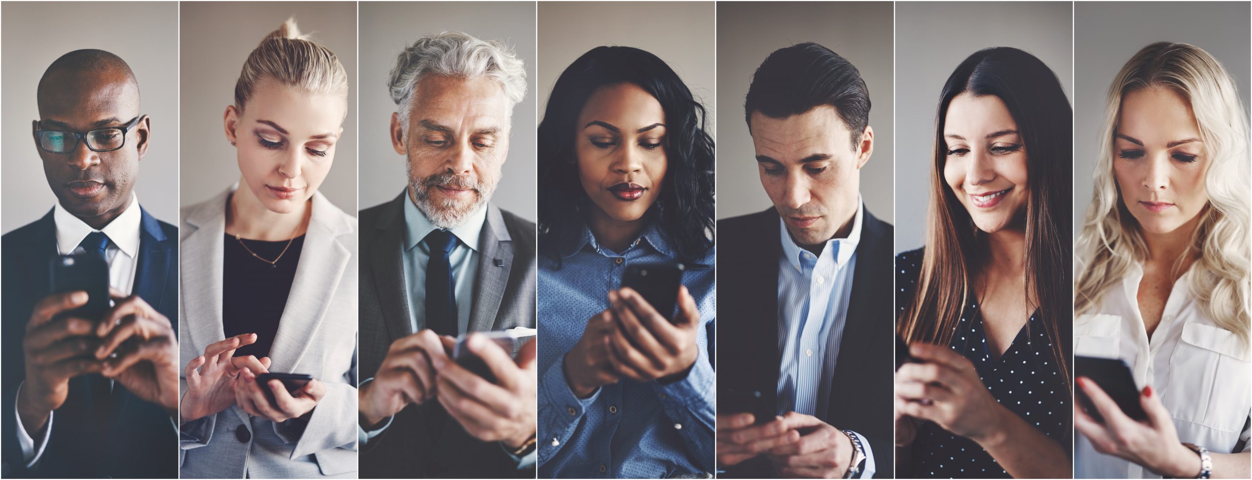 Diverse group of businesspeople reading text messages on cellphones